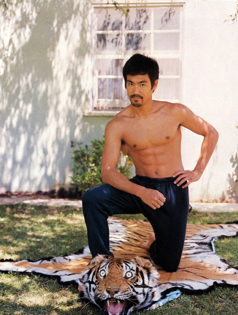 Bruce Lee kneeling on tiger rug