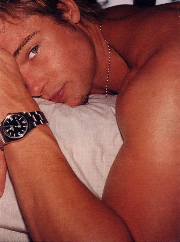 pic of actor brad pitt laying down showing off his muscular arms