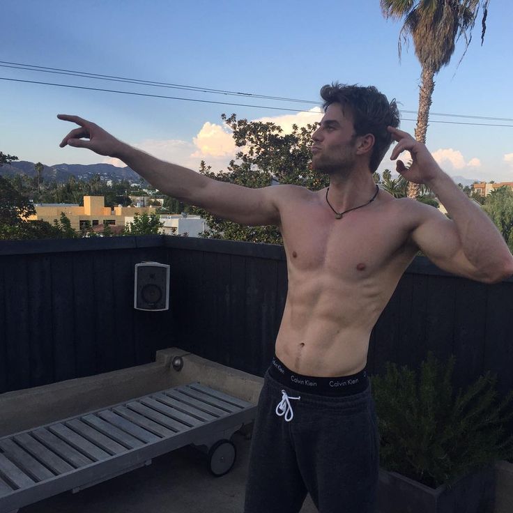 australian actor nathaniel buzolic pointing and shirtless showing abs