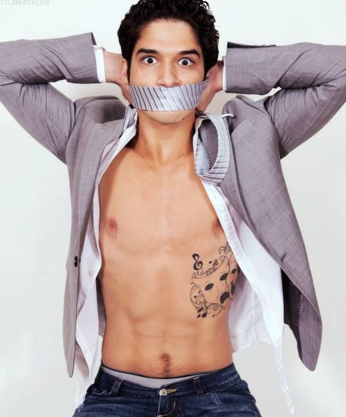 gorgeous man Tyler Posey with duck tape on his mouth and open shirt showing off his abs