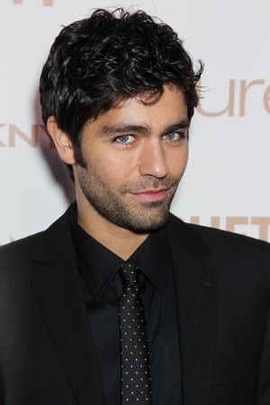 adrian grenier in a black suit tilting his head and looking well groomed