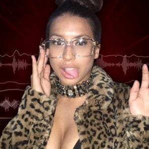 Montia in a leopard coat with her tongue out and glasses on